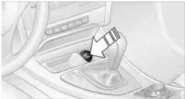 Interior view of a car showing a car gear shift lever and wheel (no text or symbols visible)