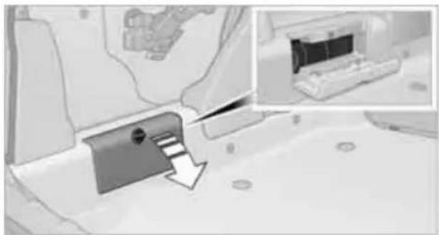 Interior view of a vehicle showing a mounted device with a highlighted arrow pointing to it, and an inset image of a vehicle (no visible text or symbols)