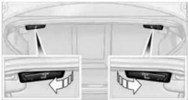 Interior view of a car showing rearview and side-mounted buttons with directional arrows (no text or symbols)