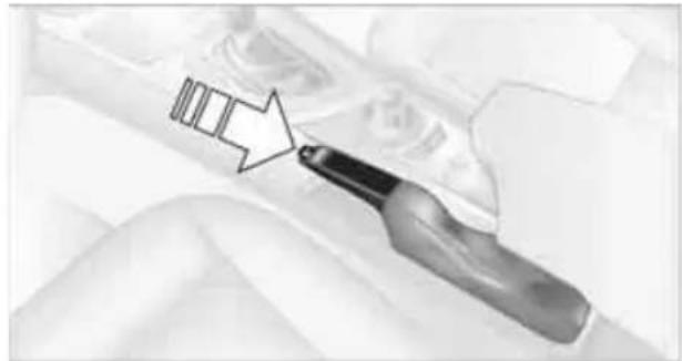 Close-up of a hand holding a pen tip, pointing to a small object with an arrow (no text or symbols visible)