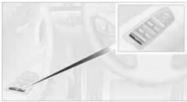 Close-up of a medical or laboratory tool with a metallic rod and a close-up inset showing a labeled object (no visible text or symbols)