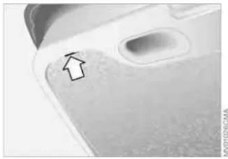 Close-up of a smartphone face showing a small up arrow on the cheek (no text or symbols visible)
