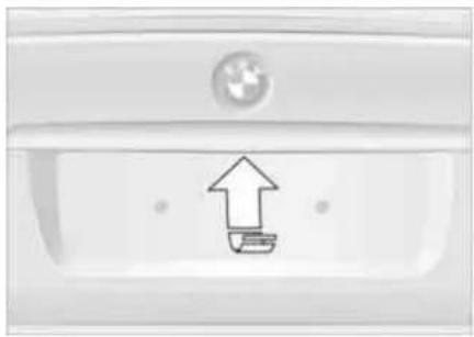 Close-up of a white car door with a circular emblem and an upward arrow icon (no text or symbols)