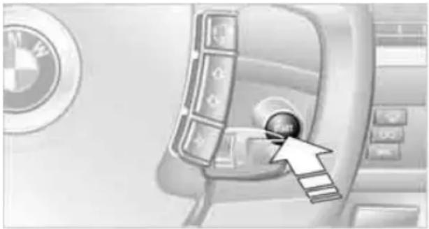 Interior view of a car infotainment system with a BMW logo and directional arrow (no text or symbols)
