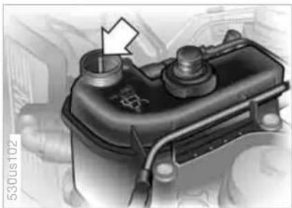 Close-up of a mechanical component with a white arrow pointing to a cylindrical feature (no visible text or symbols)