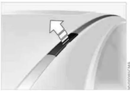 Close-up of a car wheel rim with a black plastic clip and an arrow pointing to the edge (no text or symbols visible)