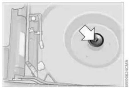 Mechanical component diagram showing a circular housing with a central knob and an arrow pointing to the knob (no text or symbols present)