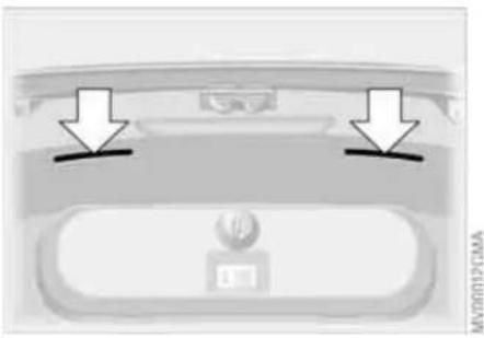Top-down view of a car rear bumper with two arrows pointing to the front panel (no text or symbols visible)