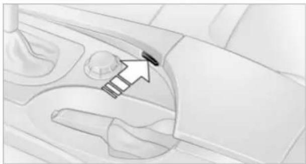 Diagram of a car interior showing a hand holding a small object, with an arrow pointing to it (no text or symbols present)