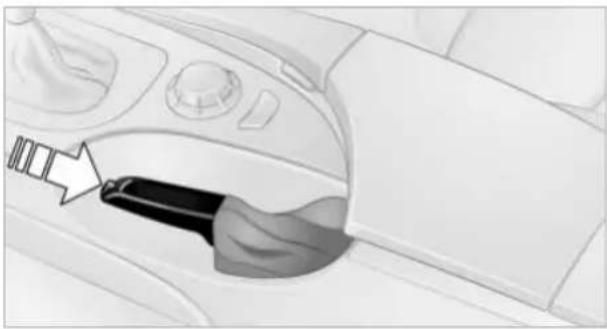Interior view of a car showing a hand inserting a belt switch into the dashboard (no text or symbols visible)