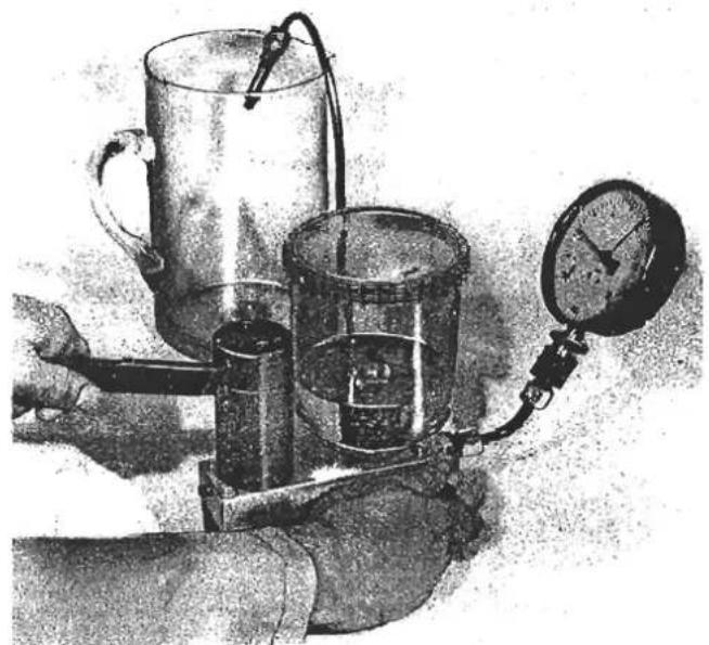 Illustration of a mechanical device with a pressure gauge and cylindrical components (no visible text or symbols)