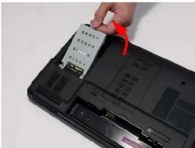 Close-up of a hand inserting a CD drive into a black laptop case, showing internal components and a red arrow indicating the component (no text or symbols visible)