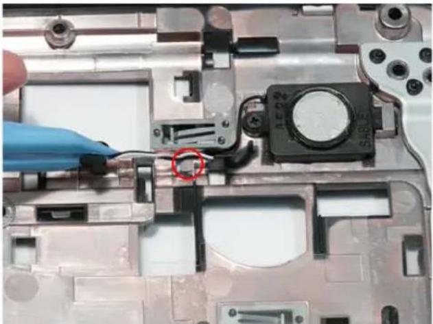 Close-up of a laptop's internal components with a blue glove and a red circle highlighting a device (no visible text or symbols).