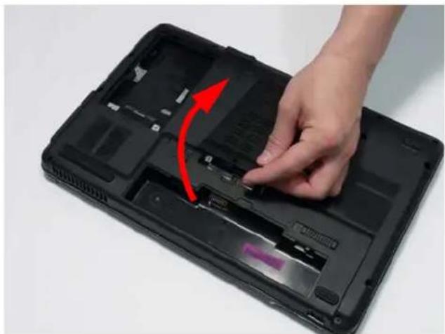 Hand placing a component into a black laptop case with a red arrow indicating rotation (no text or symbols visible)