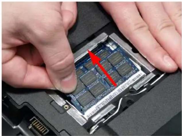 Close-up of hands installing a chip into a device component with a red arrow indicating the location (no text or symbols visible)