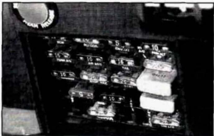 Black-and-white photo of a vintage car interior with numbered compartments and a circular logo on the left.