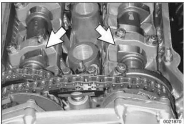 Close-up of an internal mechanical component with two white arrows pointing to specific parts (no visible text or symbols)