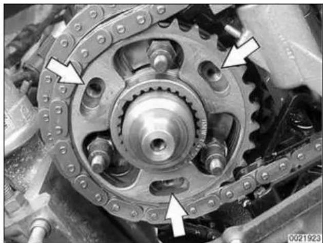 Close-up of a mechanical gear assembly with chain links and mounting holes (no visible text or symbols)