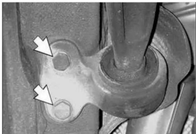 Close-up of a mechanical component with two white arrows pointing to features, no visible text or symbols.