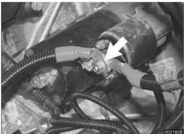 Close-up of mechanical hoses and connectors with a white arrow pointing to a component, no visible text or symbols.