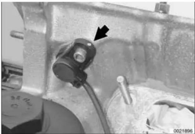 Close-up of a mechanical component with a black arrow pointing to a small component (no visible text or symbols).