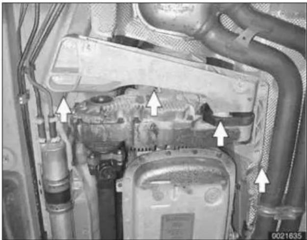 Interior view of an automotive engine bay with visible structural components and directional arrows indicating parts of the engine. No text or symbols present.