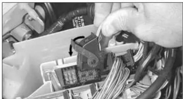 Close-up of hands installing or adjusting a circuit board component with wires (no visible text or symbols)