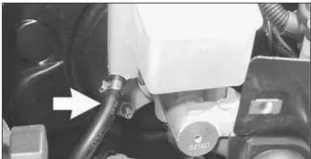 Close-up of a mechanical assembly with hoses and a central component, no visible text or symbols.