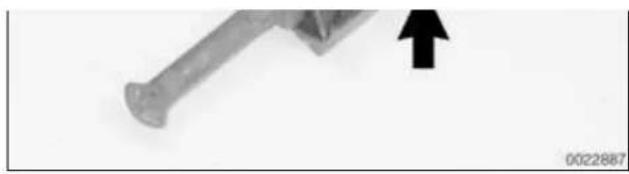 Close-up of a nail with an arrow pointing upward (no text or symbols visible).
