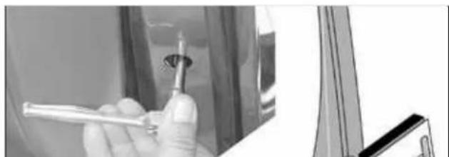 Close-up of a hand holding a screwdriver inside a car, with a partial view of the window corner (no visible text or symbols)