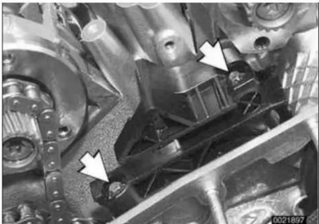 Close-up mechanical assembly with white arrows pointing to specific components (no visible text or symbols).