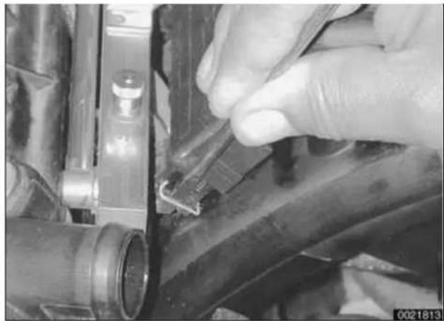 Close-up of a hand adjusting a mechanical component with visible wiring and parts (no text or symbols)