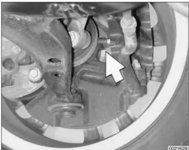 Close-up of mechanical components with a white arrow pointing to a specific part (no visible text or symbols)