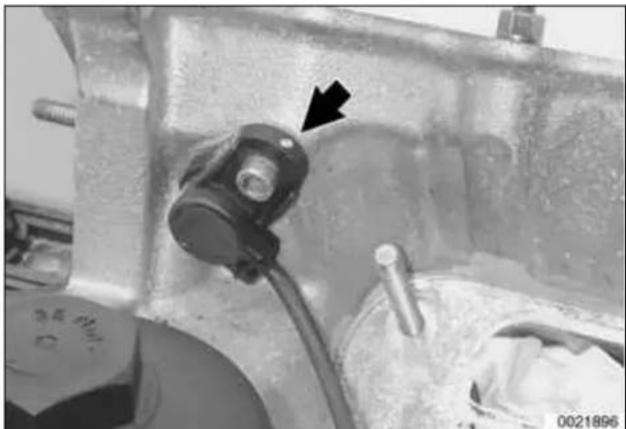 Close-up of a mechanical component with a black arrow pointing to a specific part (no visible text or symbols).