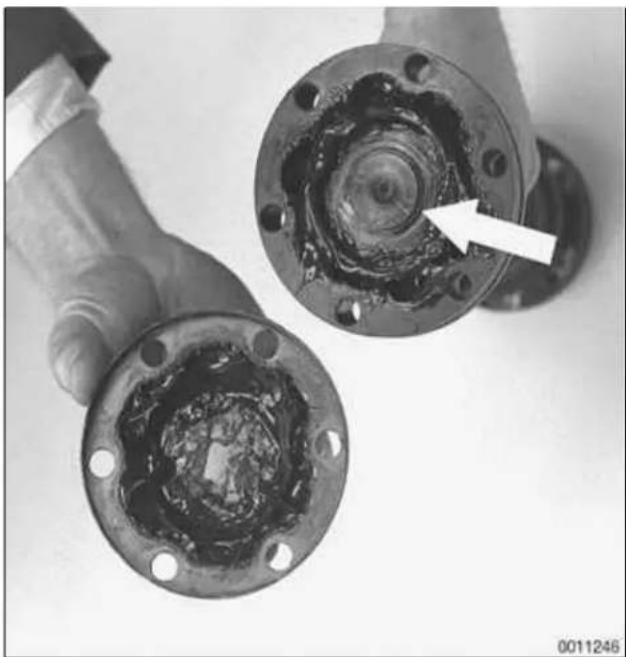 Close-up of a hand holding two mechanical components with a white arrow pointing to a circular feature (no text or symbols visible)