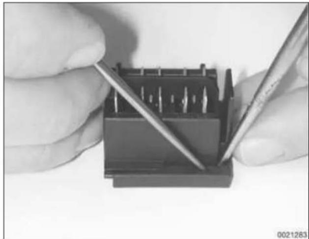 Close-up of hands using a tool to adjust or install a small electronic component (no visible text or symbols)