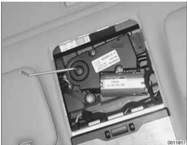 Interior view of a computer case showing an open battery with a screwdriver inserted, no visible text or symbols.