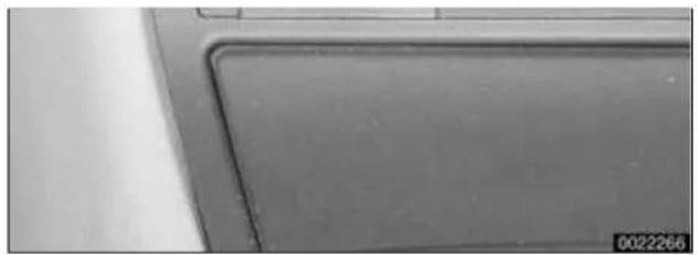 Close-up of a metallic panel edge with a visible cutting edge and a small number '0022266' in the corner (no text or symbols on the panel itself)