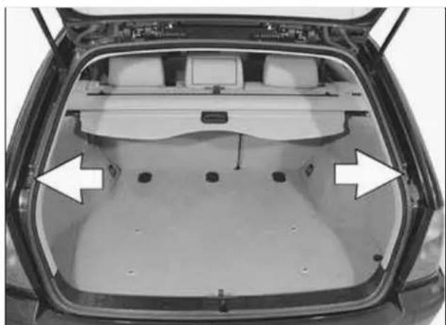 Top-down view of a car trunk with visible rear seats and side-mounted monitors (no text or symbols)