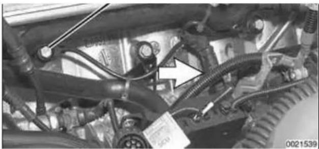 Close-up of automotive engine components with hoses and connectors (no visible text or symbols)