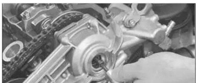 Close-up of a mechanical assembly with hands operating a tool (no visible text or symbols)