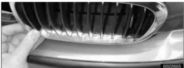Close-up of a car's grille and dashboard with a hand adjusting the grille (no visible text or symbols)
