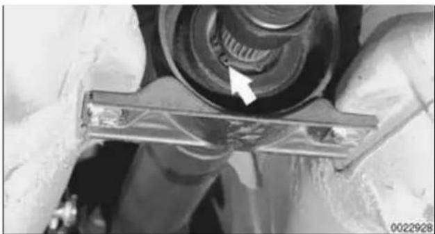 Close-up of mechanical components with a metallic bracket and a white arrow pointing to a component (no visible text or symbols)