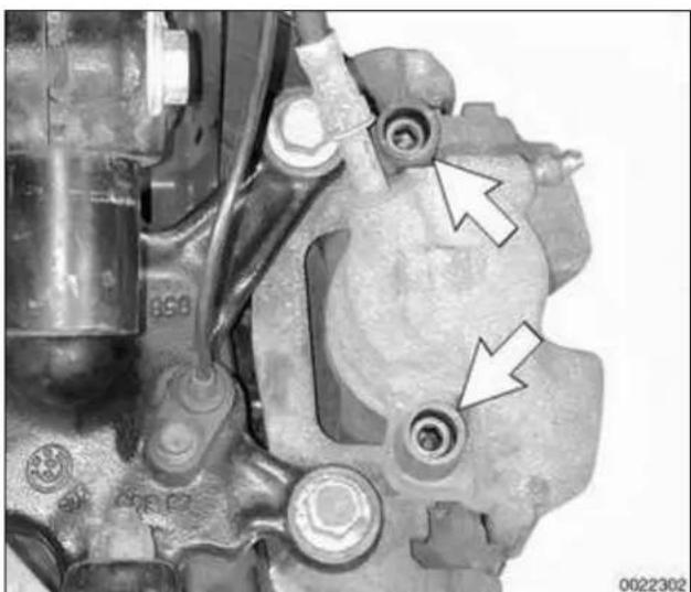 Close-up mechanical component with two white arrows pointing to features, no visible text or symbols