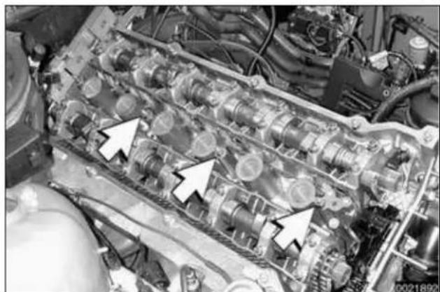 Close-up of an internal combustion engine cylinder head with visible propellers and cooling pipes (no text or symbols)