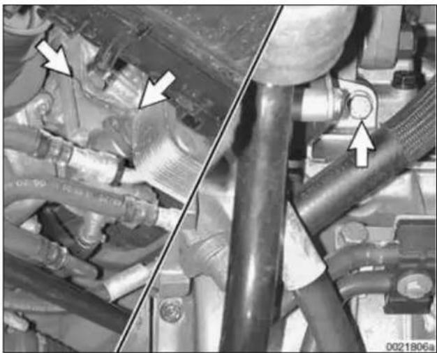 Close-up mechanical assembly showing hoses and pipes with directional arrows (no readable text or symbols)
