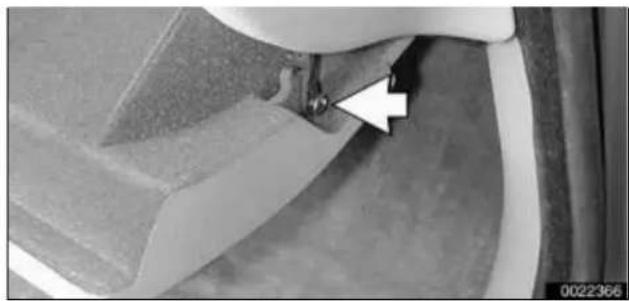 Close-up of a mechanical component with a white arrow pointing to a small feature, no visible text or symbols.