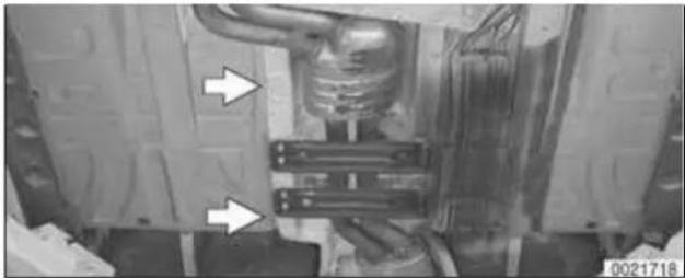 Mechanical assembly diagram showing a vehicle chassis with two white arrows pointing to specific components (no text or symbols present)