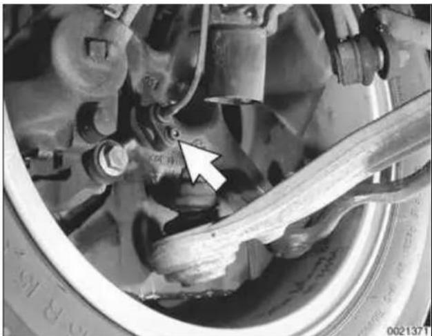 Close-up of a car brake system with a white arrow pointing to the wheel (no visible text or symbols)