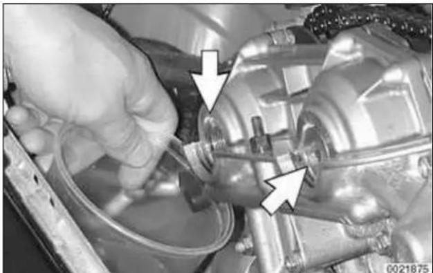 Close-up of a hand inspecting or adjusting a mechanical component with arrows pointing to specific parts (no visible text or symbols)